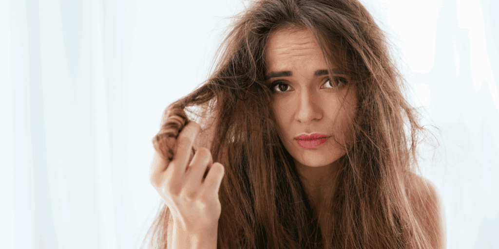 Mulher com cabelo seco, opaco e com frizz, representando a necessidade de um cronograma capilar.