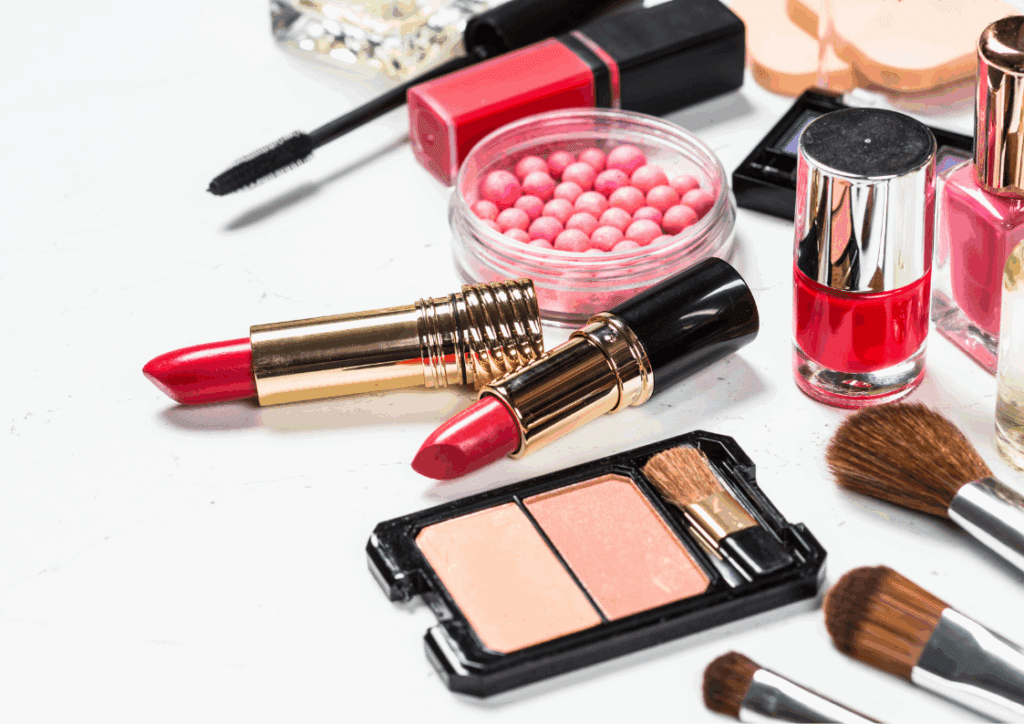 Produtos de maquiagem essenciais, incluindo paleta de sombras e pincéis, organizados em uma superfície de mármore.