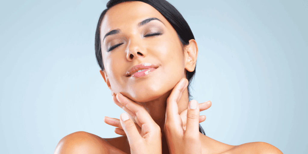 Mulher feliz e confiante mostrando a pele do nariz lisinha, sem cravos, resultado dos melhores produtos de skincare.