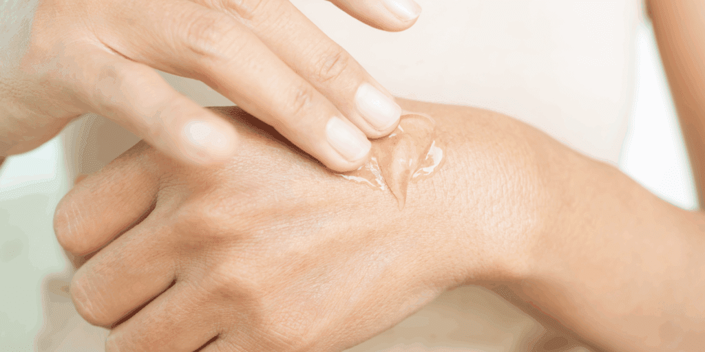 Mão de uma mulher mostrando a textura leve de um hidratante em gel para a primavera na ponta dos dedos.