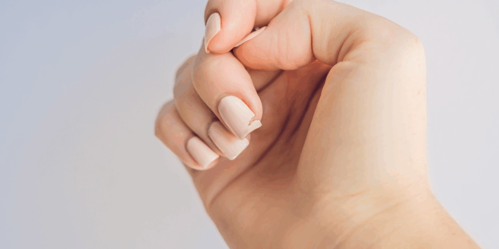 Unha feminina com esmalte e quebrada