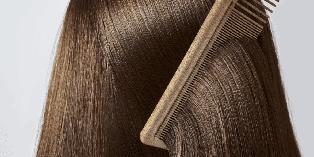 Um close-up de "nuca" ou lateral de um cabelo liso (pode ser castanho ou loiro), super brilhante e alinhado, talvez com uma escova passando suavemente por ele.