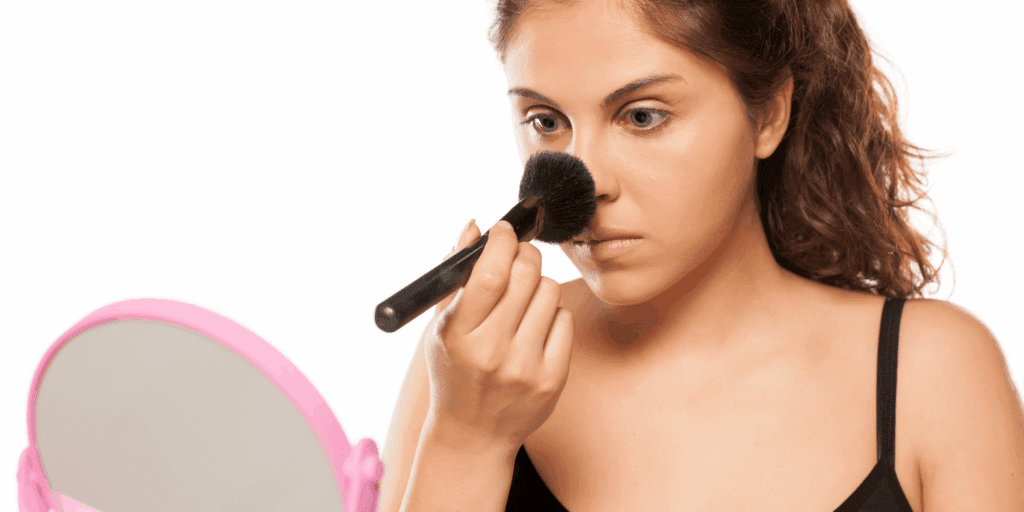 Uma foto de uma mulher aplicando pó compacto na Zona T (nariz/testa) com uma esponjinha ou pincel. O foco deve ser no efeito matte (o "antes" brilhante vs. o "depois" opaco) ou na leveza do pó, sem parecer "pesado".